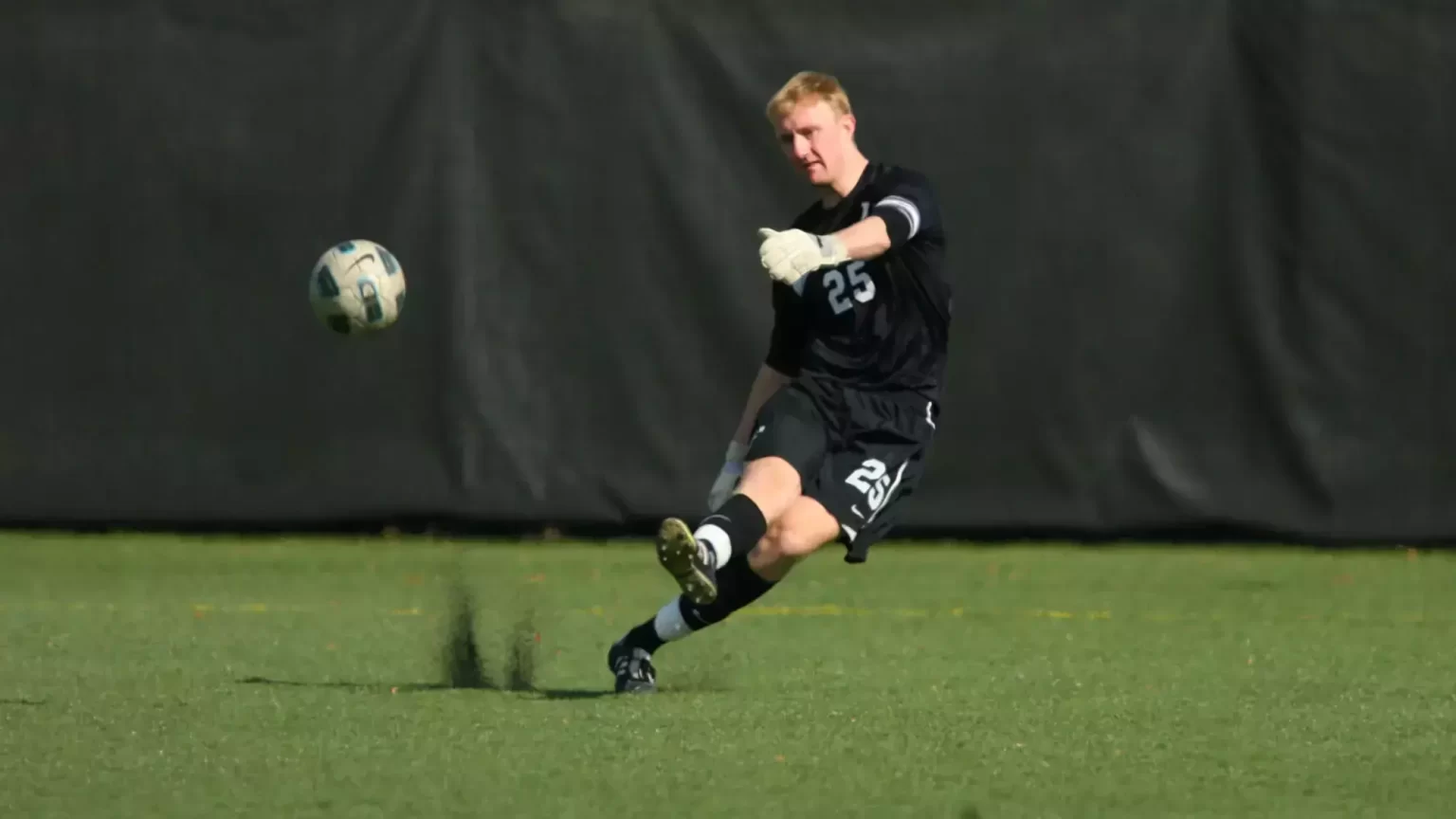 Ryan Meara, kicking a soccer ball on field