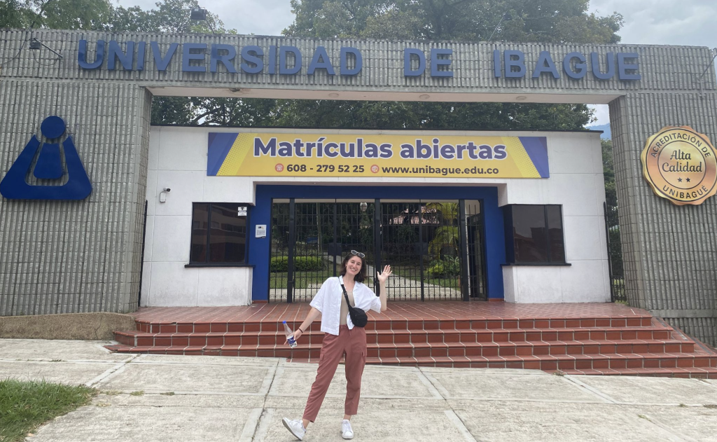 A woman poses in front of in front of the Universidad de Ibague in Colombia.